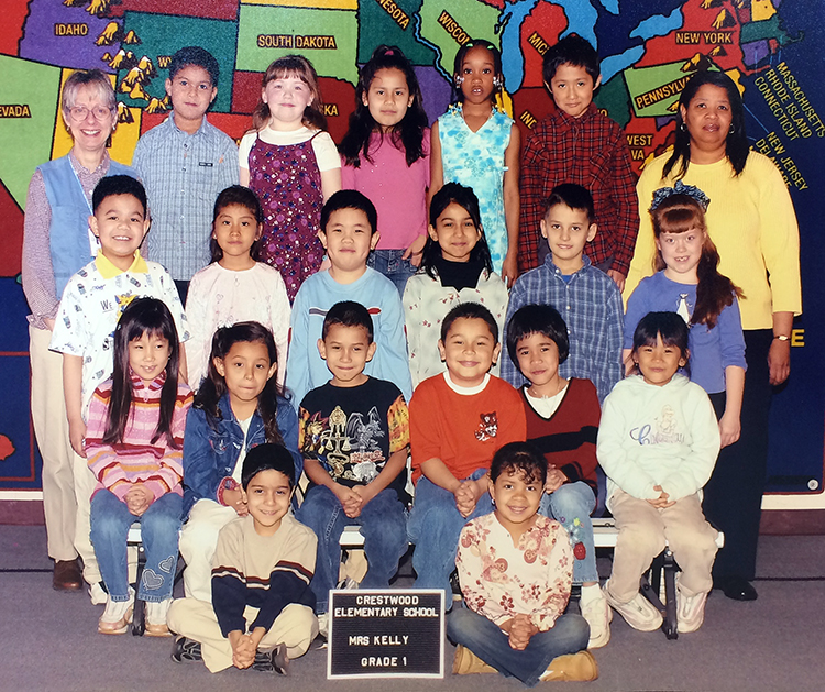Color photograph from our 2003 to 2004 yearbook showing Mrs. Kelly's first grade class. 19 children and two teachers are pictured.